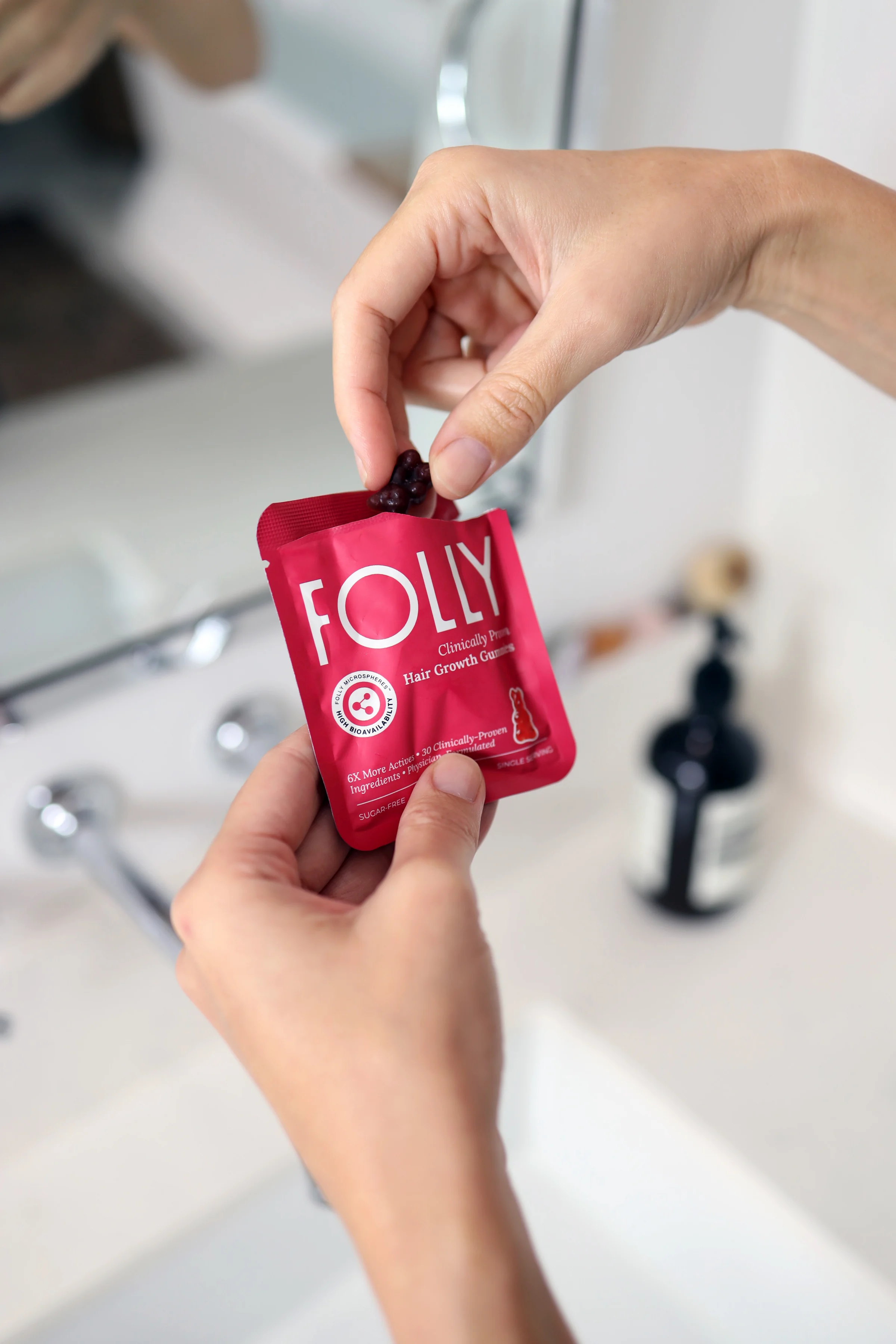 Hand holding a Folly sachet in a lifestyle setting